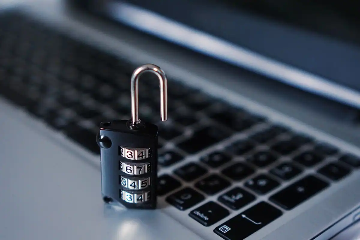 Lacăt cu cifru așezat pe tastatura unui laptop, simbol al securității